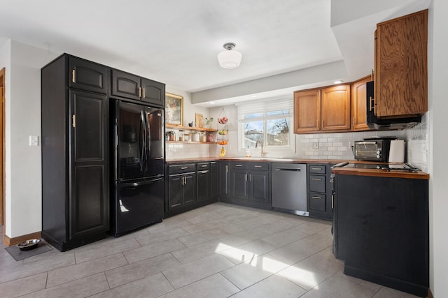 kitchen with black refrigerator, tasteful backsplash, and stainless steel dishwasher