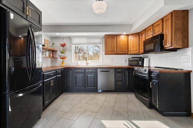 kitchen with tasteful backsplash, sink, black appliances, and light tile patterned flooring