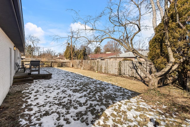 yard layered in snow with a patio