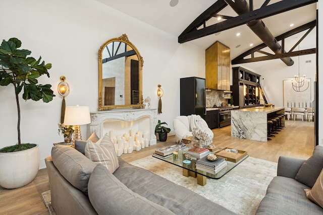 living room with high vaulted ceiling, light hardwood / wood-style flooring, a notable chandelier, beamed ceiling, and a premium fireplace