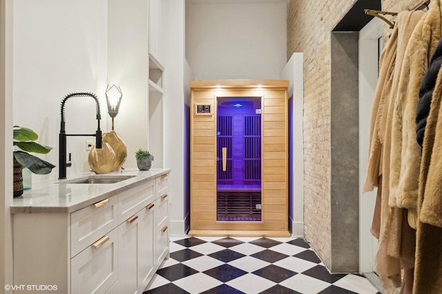 hallway with brick wall and sink