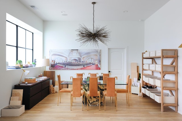 dining space with an inviting chandelier and light hardwood / wood-style floors