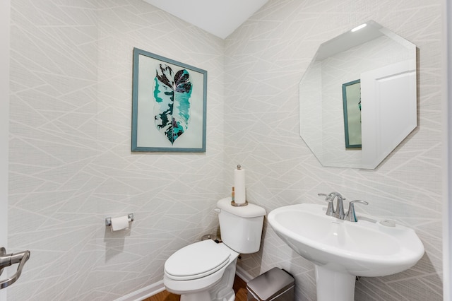 bathroom with sink, tile walls, and toilet