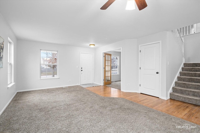 unfurnished living room featuring ceiling fan, plenty of natural light, and carpet flooring