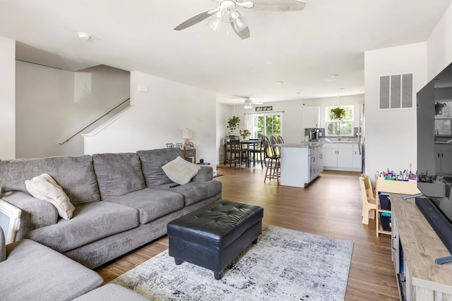 living room with ceiling fan, dark hardwood / wood-style floors, and sink