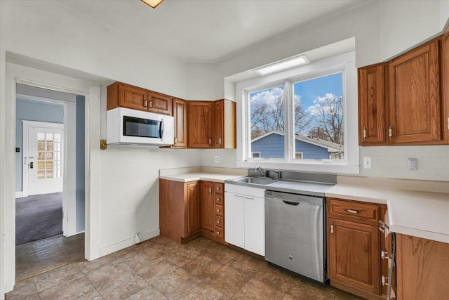 kitchen with stainless steel dishwasher, sink, and backsplash