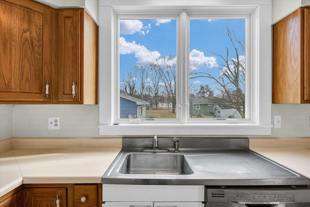 kitchen featuring dishwasher, sink, and backsplash