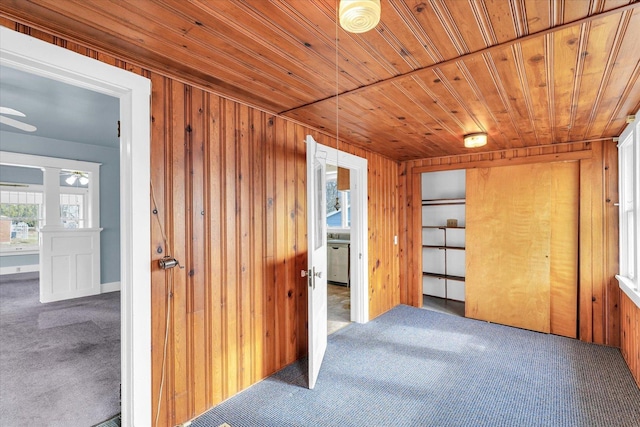 interior space featuring wood ceiling, wood walls, and carpet flooring