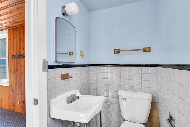 bathroom with sink, tile walls, and toilet