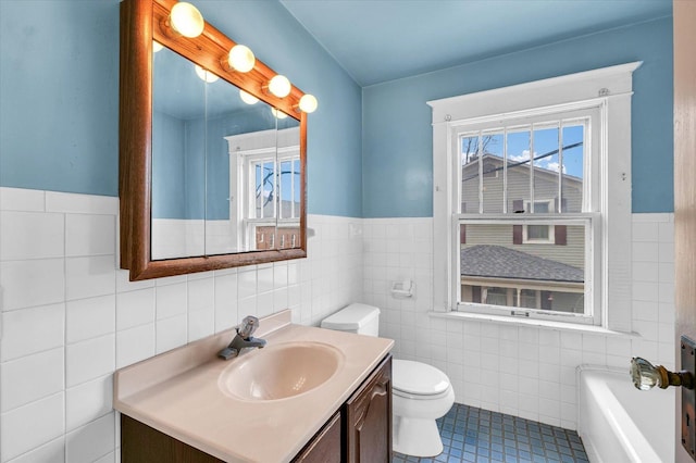 bathroom with vanity, a healthy amount of sunlight, tile walls, and toilet