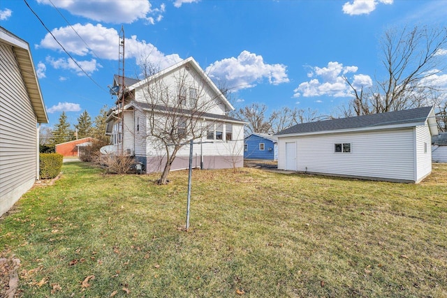 back of house with a yard and an outdoor structure