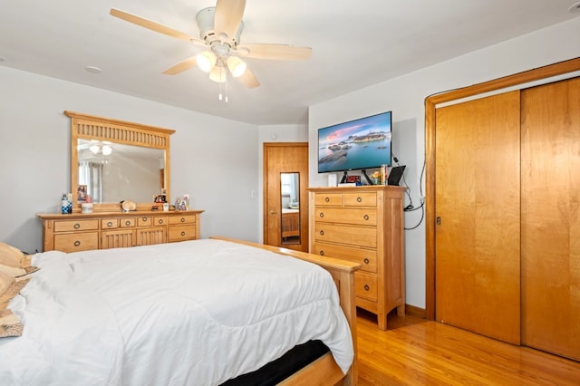 bedroom with ceiling fan, light hardwood / wood-style floors, and a closet