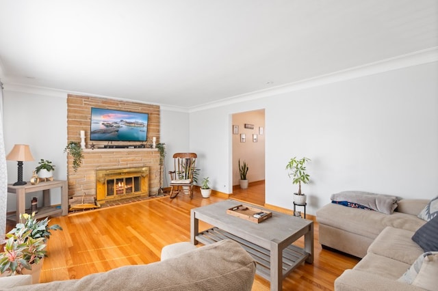 living room featuring hardwood / wood-style flooring, ornamental molding, and a fireplace