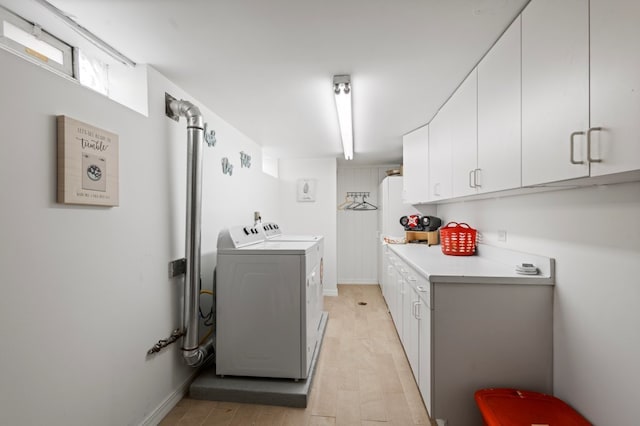 laundry area featuring light wood-type flooring, cabinets, and independent washer and dryer