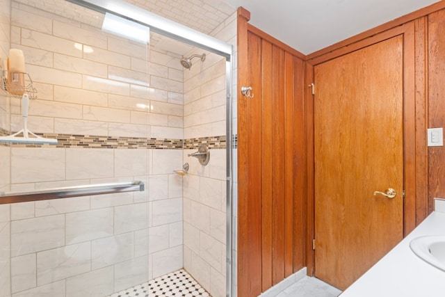 bathroom featuring a shower with door and vanity