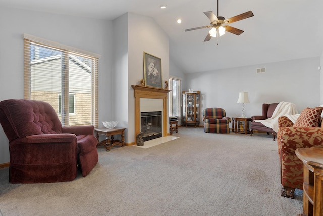 carpeted living room with ceiling fan, vaulted ceiling, and a healthy amount of sunlight