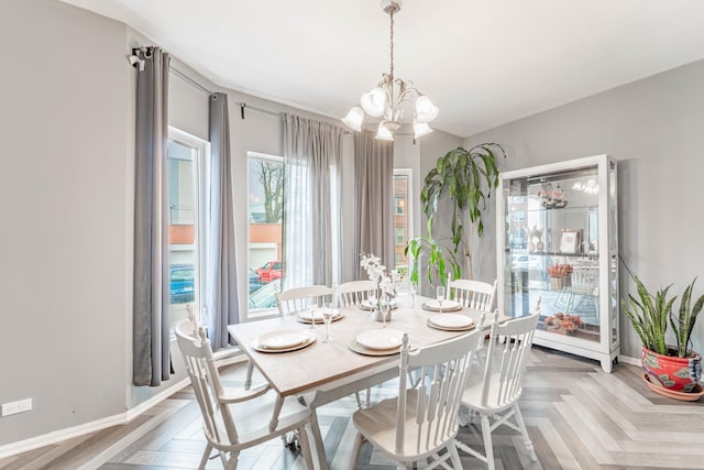 dining room with parquet floors and an inviting chandelier