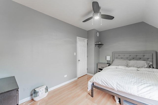 bedroom with ceiling fan, lofted ceiling, and light wood-type flooring