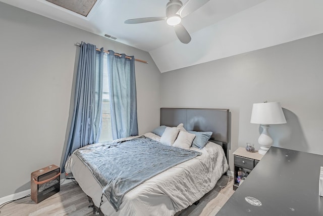 bedroom featuring ceiling fan, light hardwood / wood-style floors, and vaulted ceiling