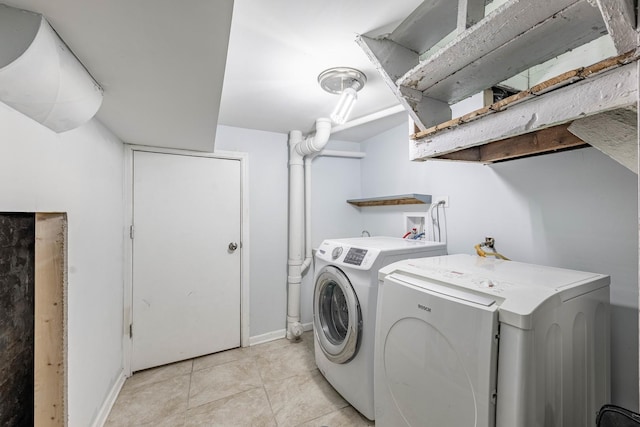 laundry room with separate washer and dryer and light tile patterned flooring