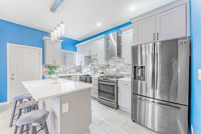 kitchen featuring a center island, sink, a kitchen breakfast bar, stainless steel appliances, and wall chimney exhaust hood