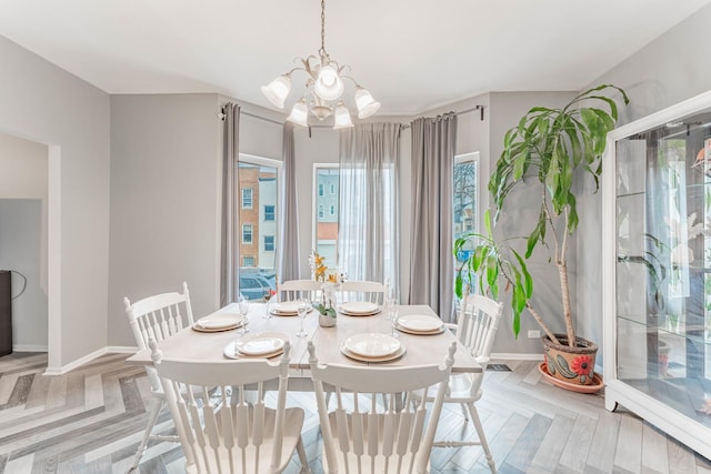 dining space featuring an inviting chandelier and light parquet flooring