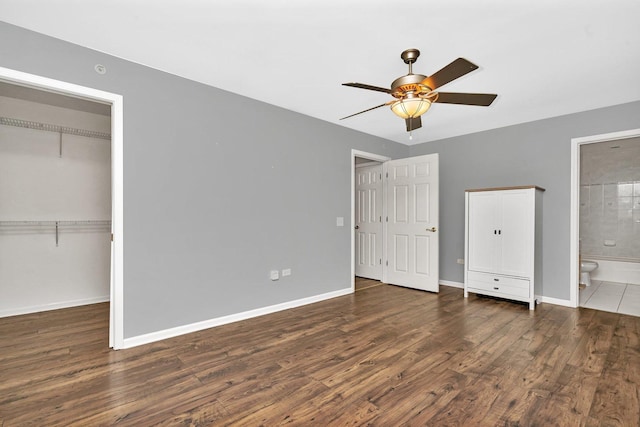 unfurnished bedroom with ceiling fan, ensuite bathroom, a closet, and dark hardwood / wood-style floors