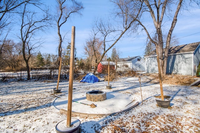 yard covered in snow featuring an outdoor fire pit