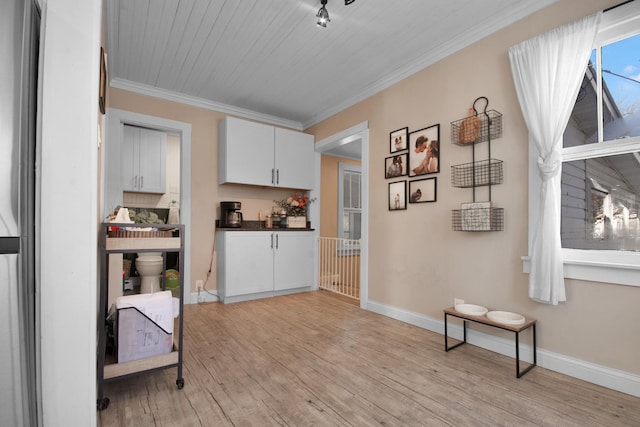 interior space featuring white cabinets, crown molding, and light hardwood / wood-style flooring