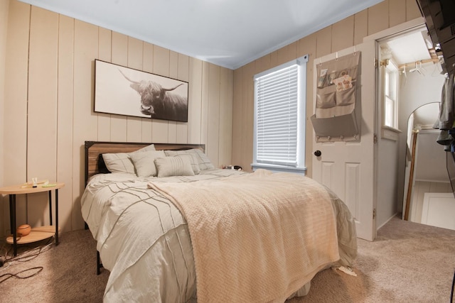 bedroom featuring carpet, wooden walls, and multiple windows