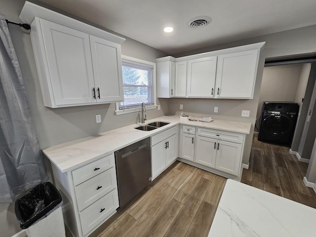 kitchen featuring washer / dryer, black dishwasher, white cabinets, and sink