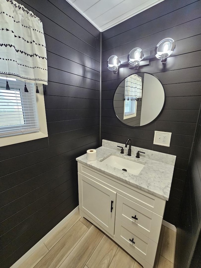 bathroom featuring wood walls and vanity