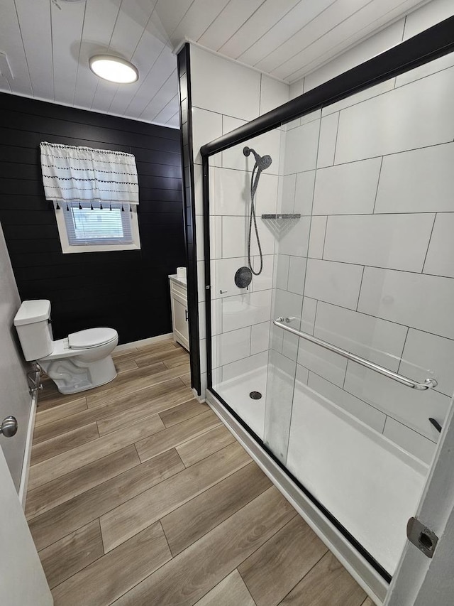 bathroom featuring toilet, a shower with shower door, and vanity