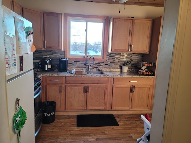 kitchen featuring decorative backsplash, dark hardwood / wood-style floors, sink, and white fridge