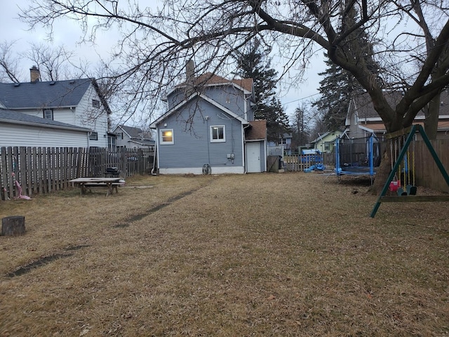 view of yard with a trampoline and a playground