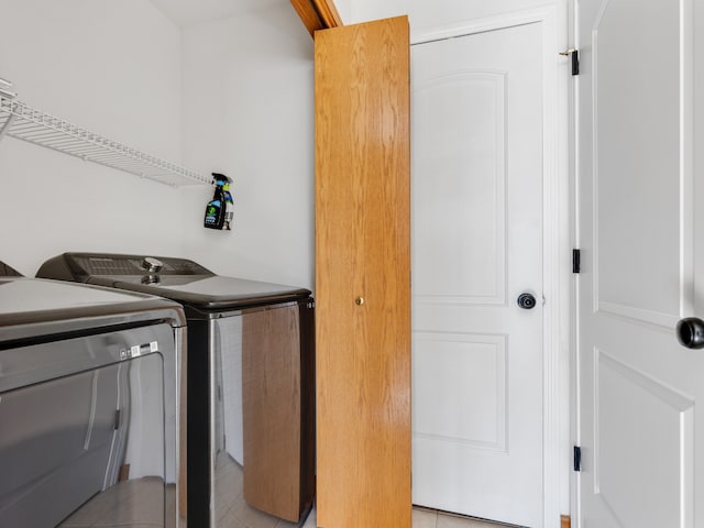 laundry room with light tile patterned floors and washing machine and clothes dryer