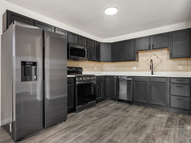 kitchen featuring backsplash, hardwood / wood-style floors, sink, and stainless steel appliances