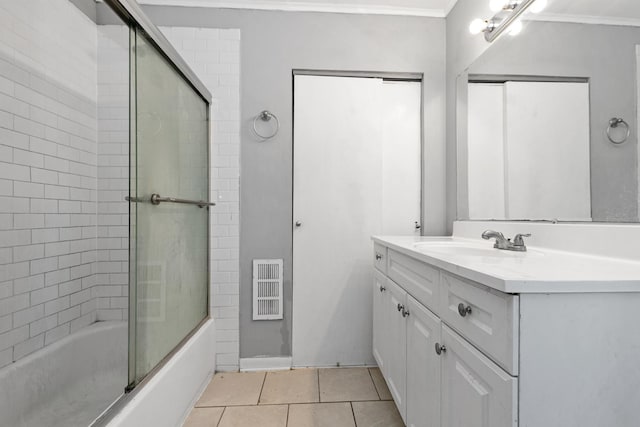 bathroom with tile patterned flooring, vanity, combined bath / shower with glass door, and crown molding