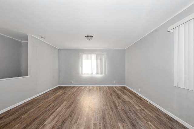 spare room with crown molding and wood-type flooring