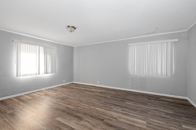 spare room with dark hardwood / wood-style flooring and crown molding