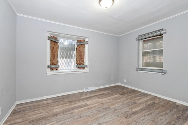 empty room featuring crown molding and hardwood / wood-style floors