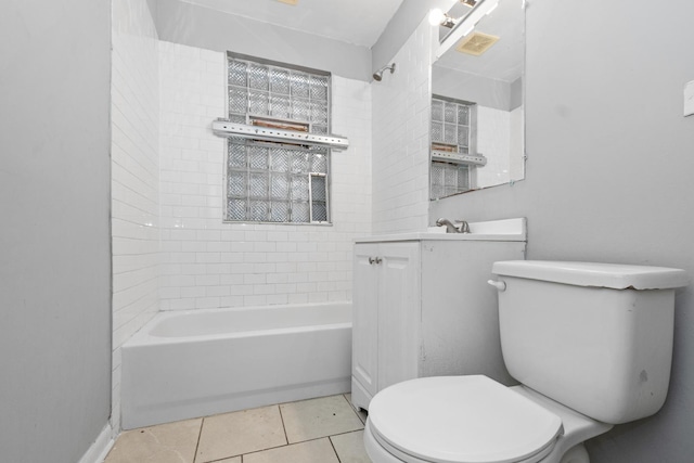 full bathroom featuring tile patterned flooring, tiled shower / bath, vanity, and toilet