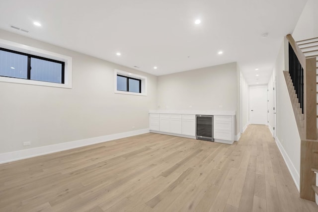 below grade area with recessed lighting, visible vents, wine cooler, and light wood-style floors