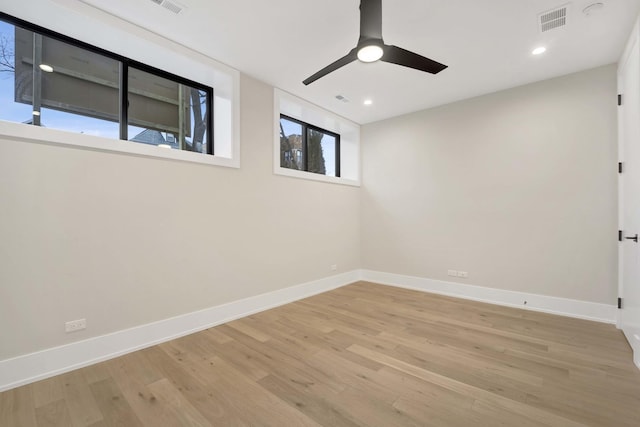 empty room featuring light wood finished floors, visible vents, recessed lighting, and baseboards