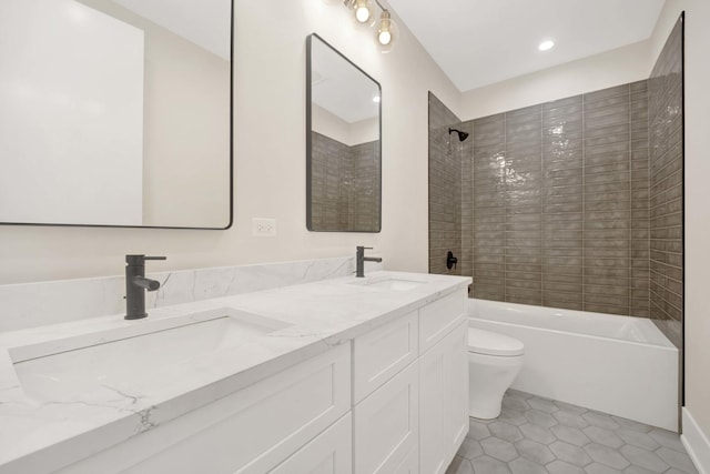 bathroom featuring double vanity, shower / bath combination, toilet, and a sink