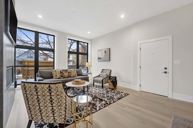 living room featuring recessed lighting, baseboards, and light wood-style floors