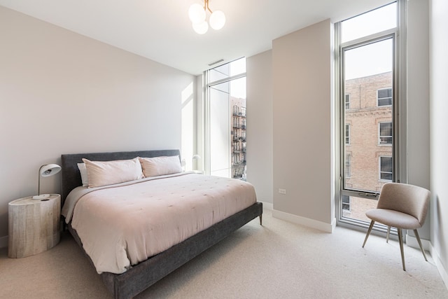 bedroom featuring floor to ceiling windows, a chandelier, light carpet, and multiple windows