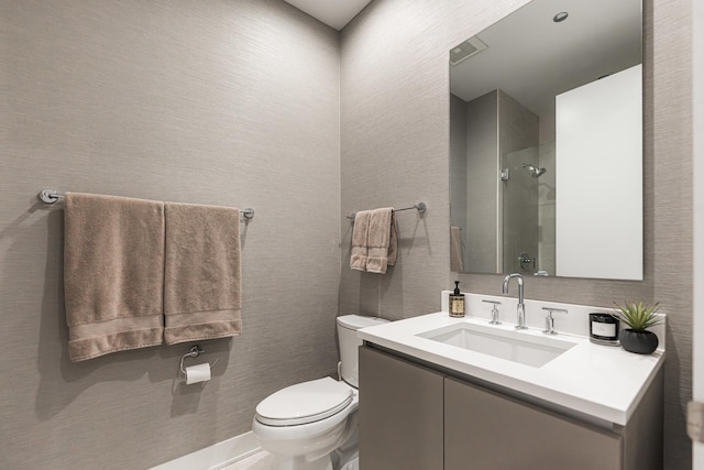 bathroom featuring vanity, toilet, and a shower with door