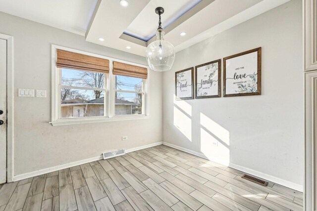 kitchen featuring wall chimney exhaust hood, appliances with stainless steel finishes, decorative backsplash, and light wood-type flooring