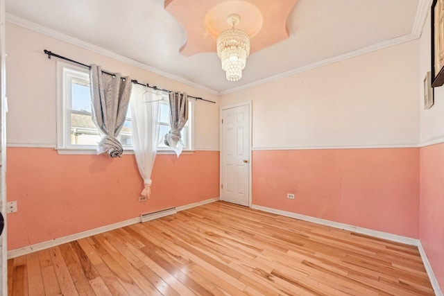 unfurnished room featuring hardwood / wood-style flooring, ornamental molding, and an inviting chandelier